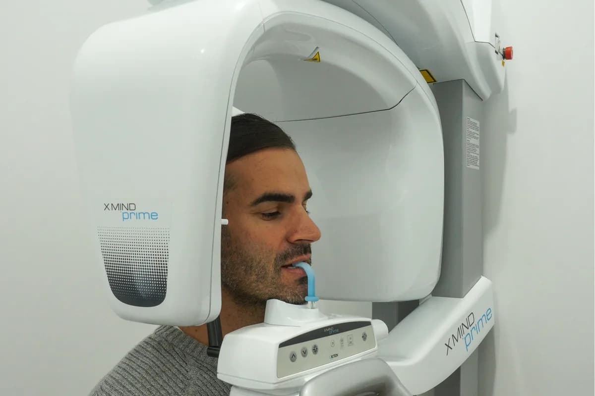 A patient standing in the panoramic X-ray machine at Dental Spot