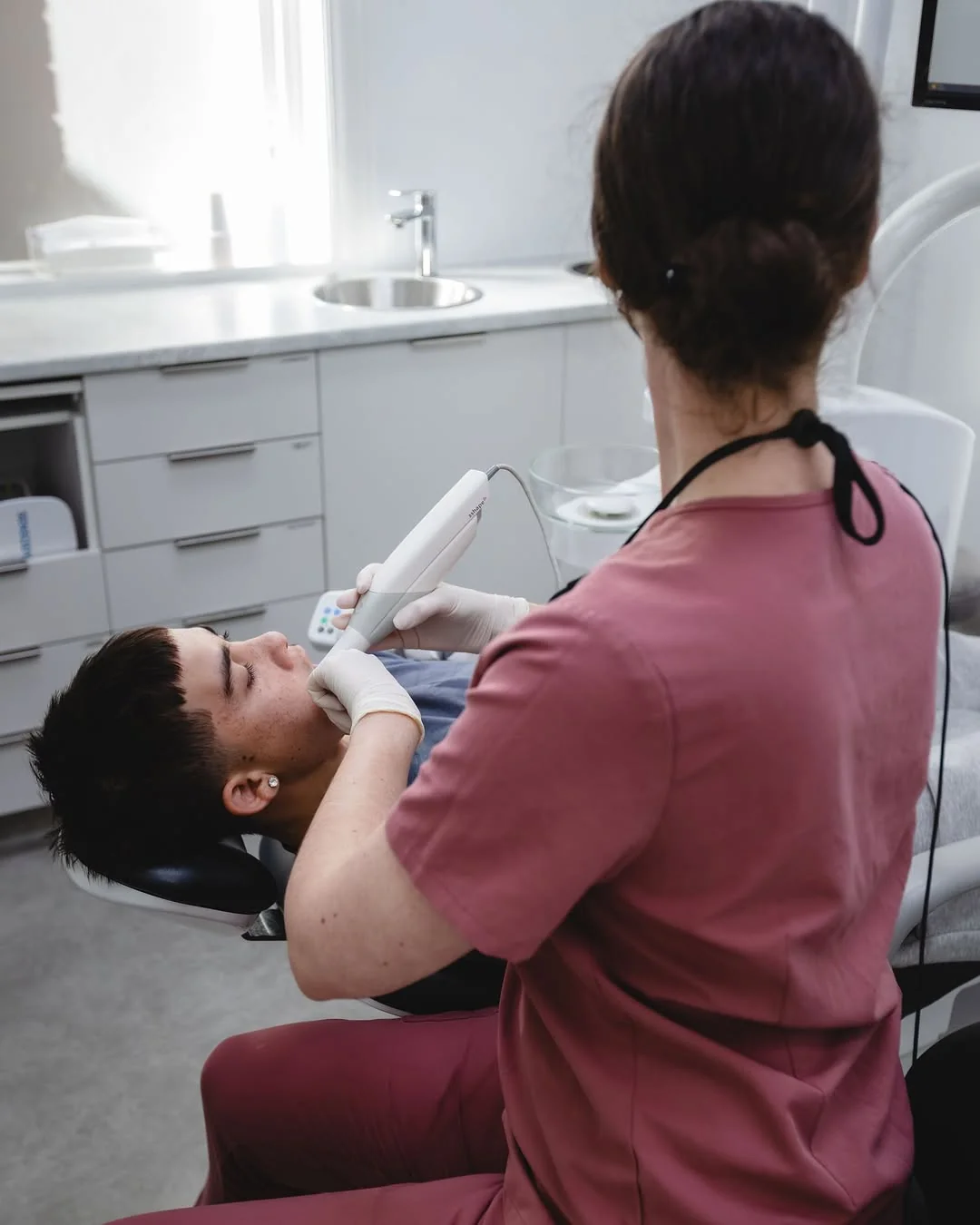 A patient’s teeth being scanned with a handheld digital scanner