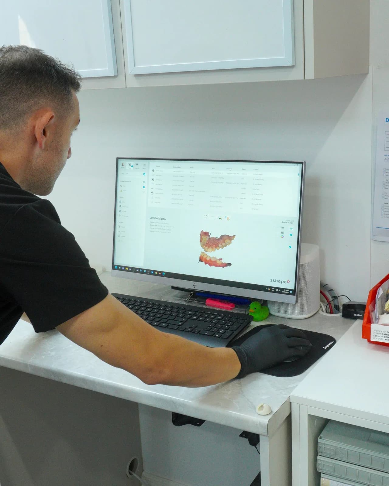 A technician designing a crown on screen in the Dental Spot lab