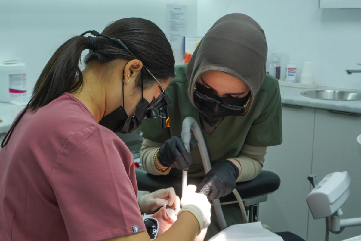 A dentist and assistant treating a patient at Dental Spot