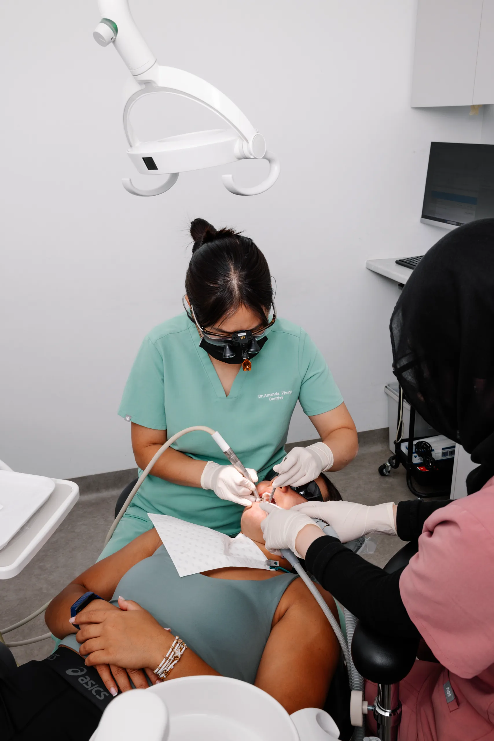 A dentist and assistant treating a patient at Dental Spot