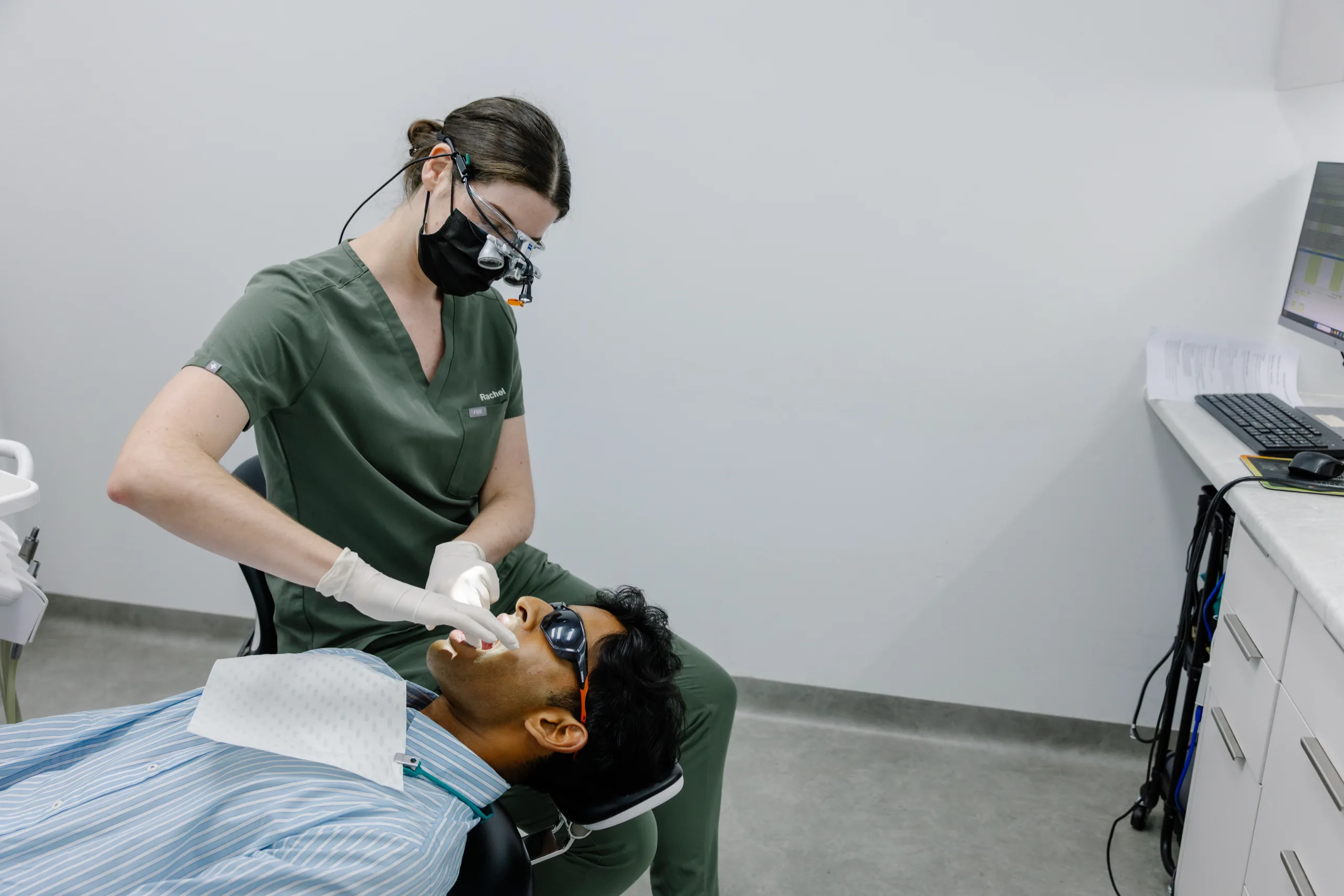A dentist examining a patient’s teeth in the dental chair