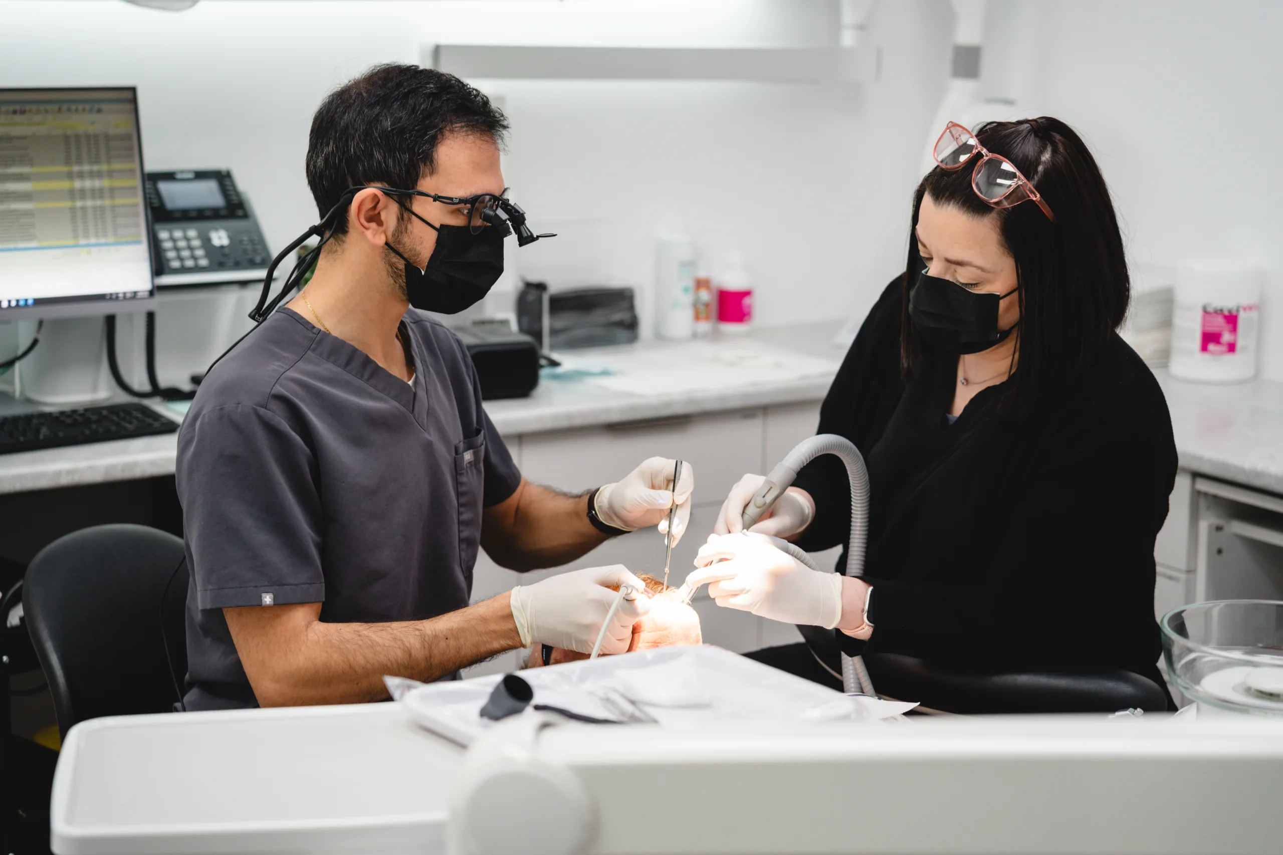 Dr Jose Shina and a dental assistant treating a patient