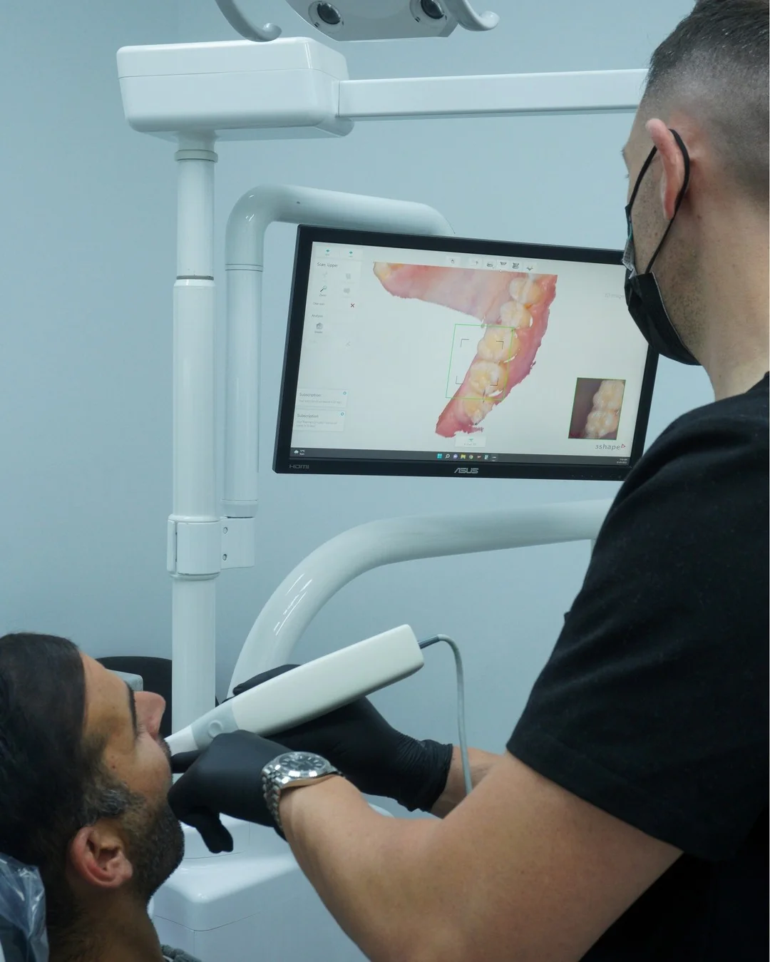 A digital scan of a patient’s teeth on the screen above the chair
