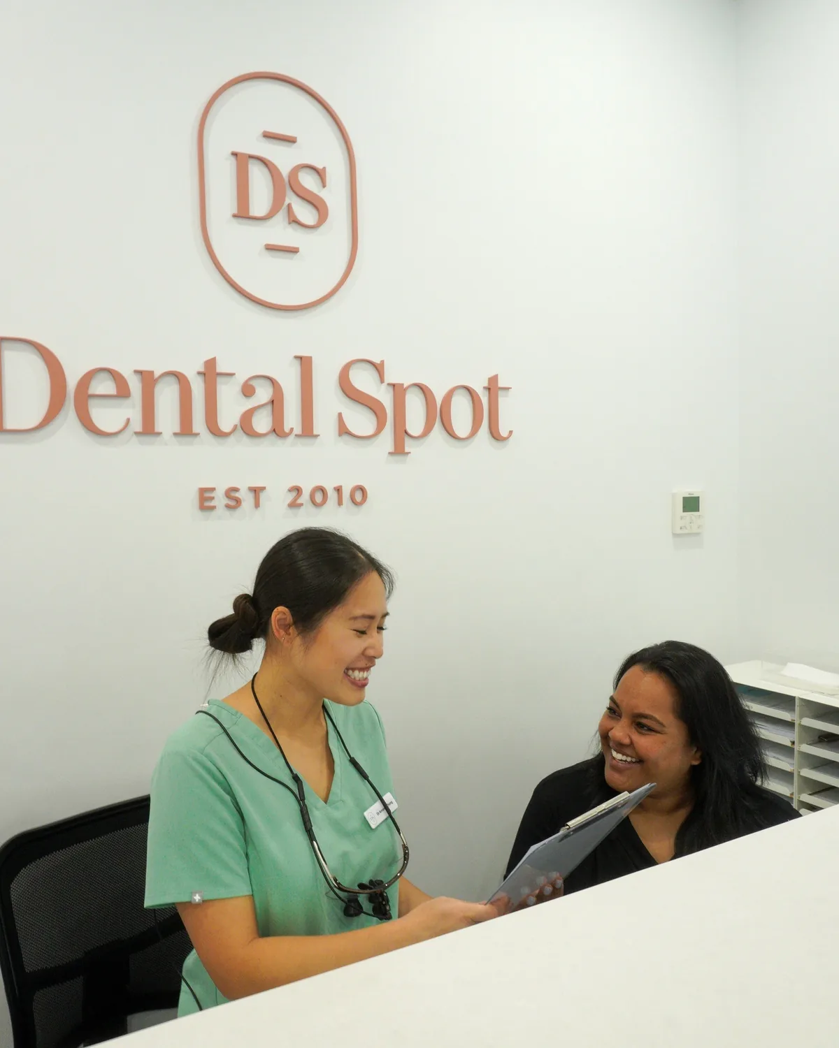 Dr Amanda Zhong going through paperwork at the Dental Spot front desk