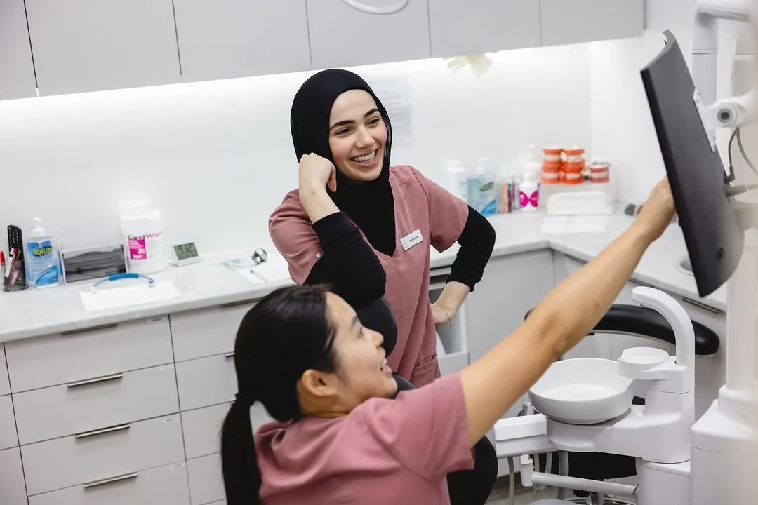 Dental Spot assistants laughing together at a monitor