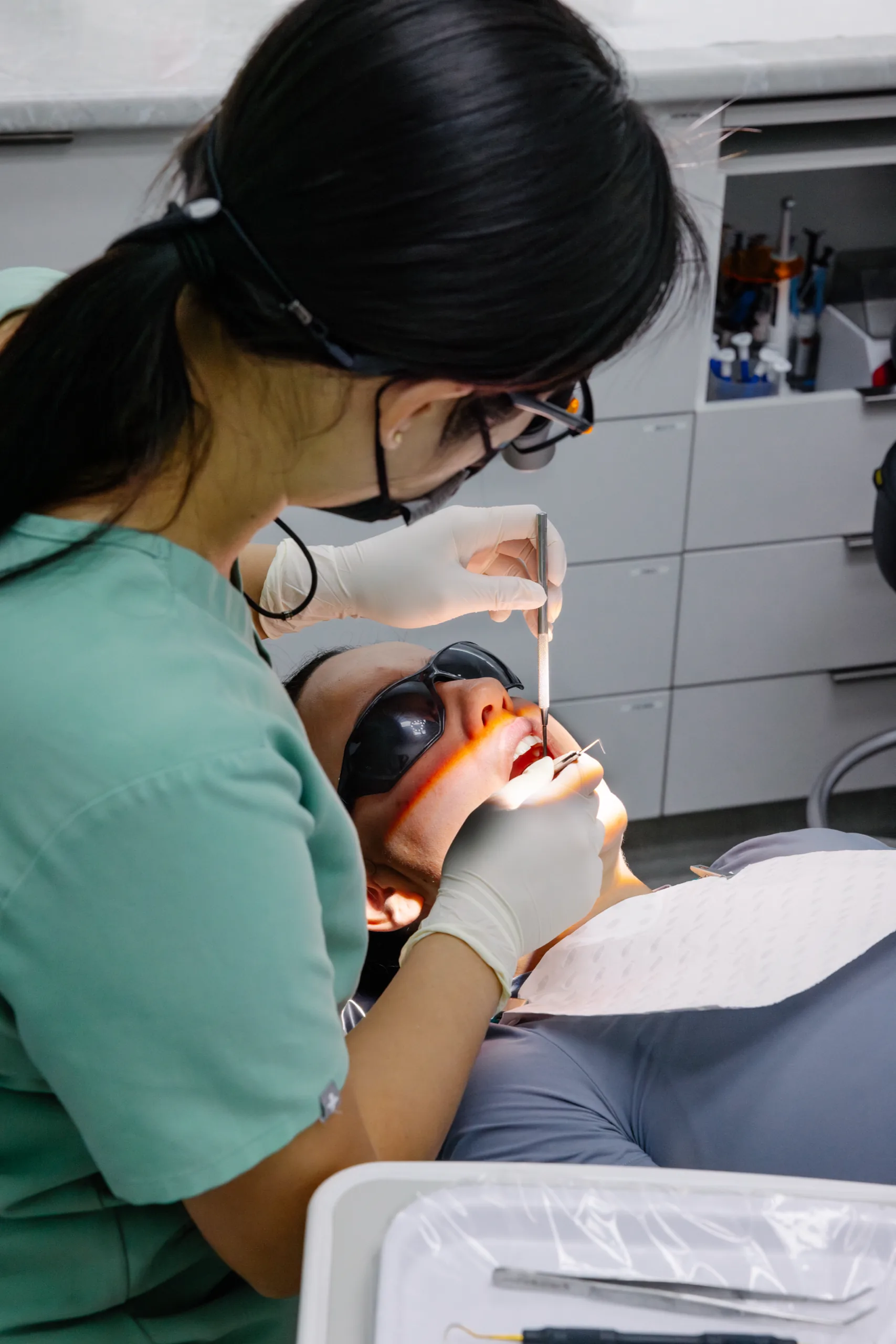 A dentist examining a patient with loupes at Dental Spot
