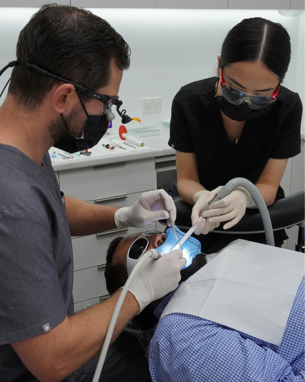 A dentist and assistant treating a patient at Dental Spot