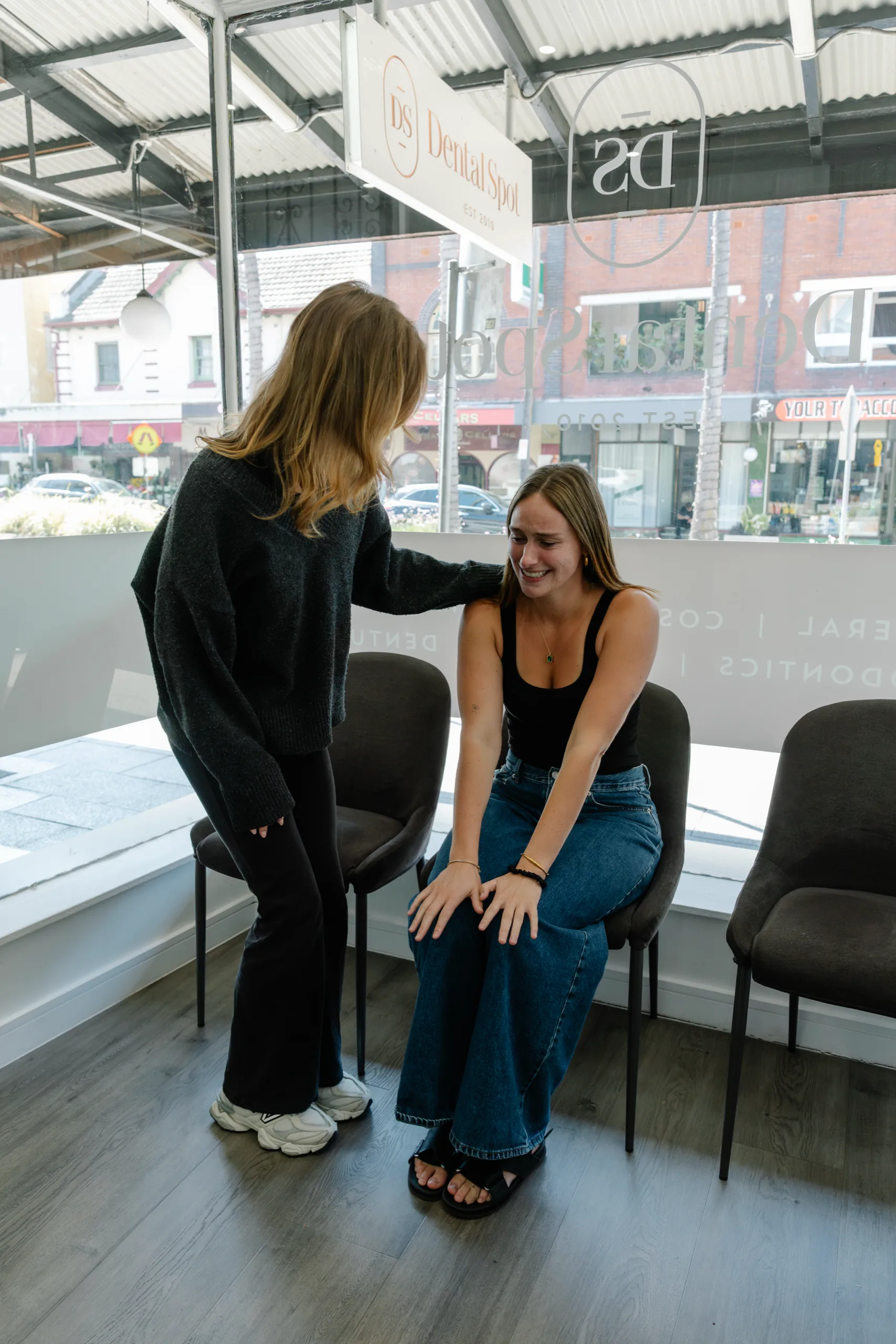 Two people laughing together in the Dental Spot waiting room