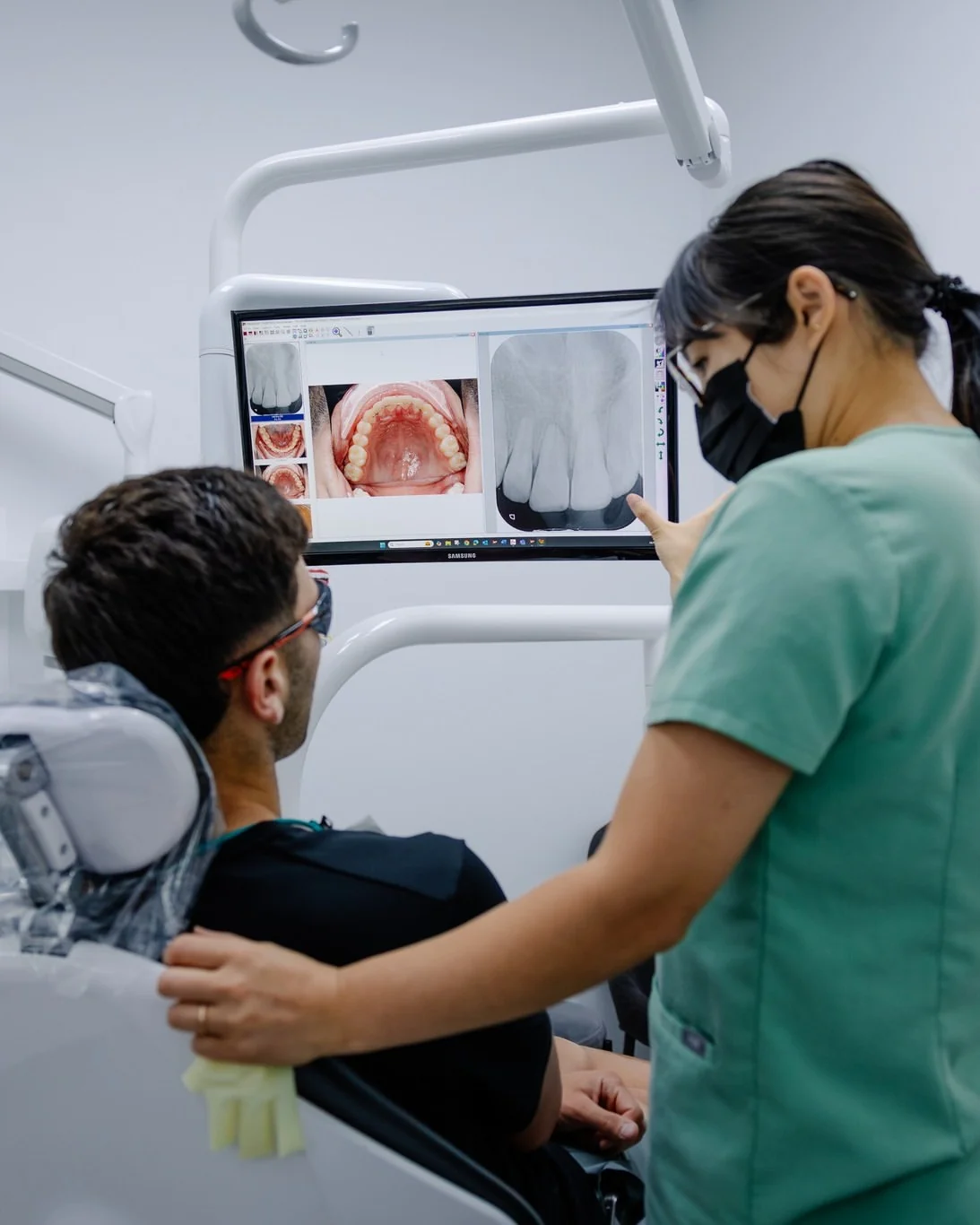 A Dental Spot dentist showing a patient an X-ray on the screen