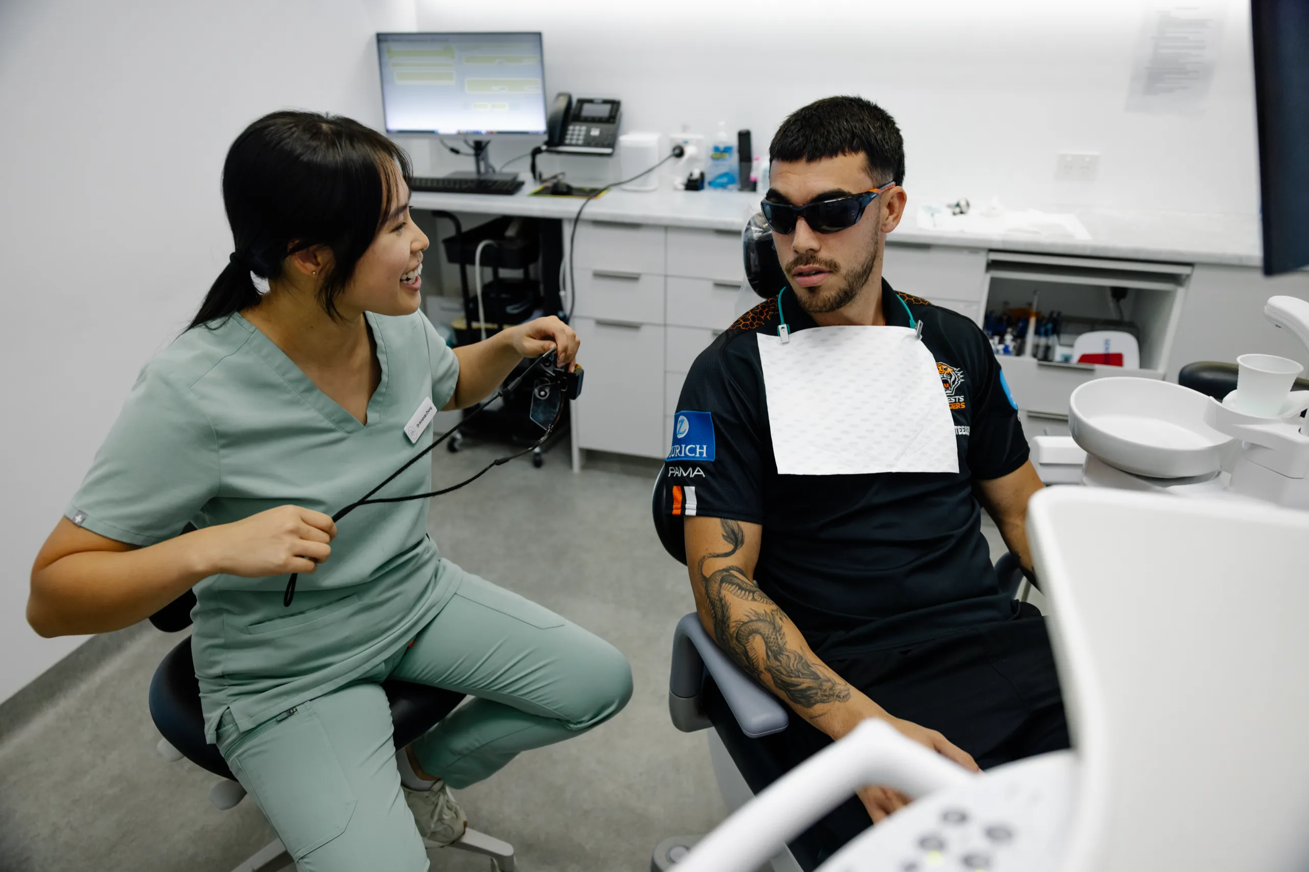 Dr Amanda Zhong laughing with a patient in the dental chair