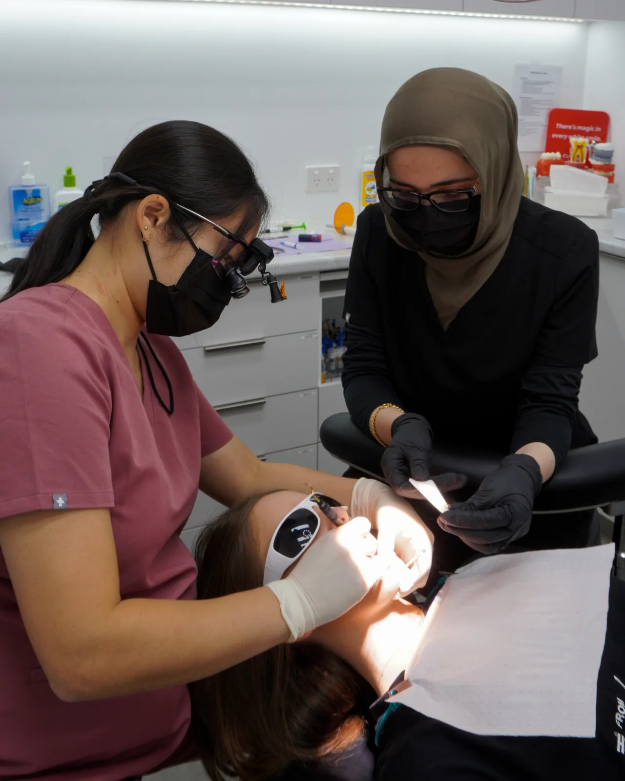 A dentist and assistant treating a patient at Dental Spot