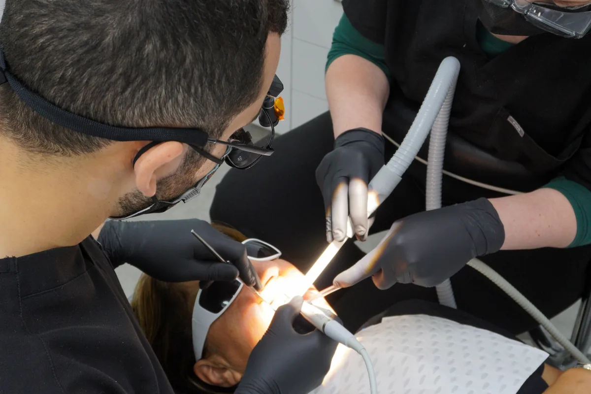 A dentist and assistant treating a patient at Dental Spot
